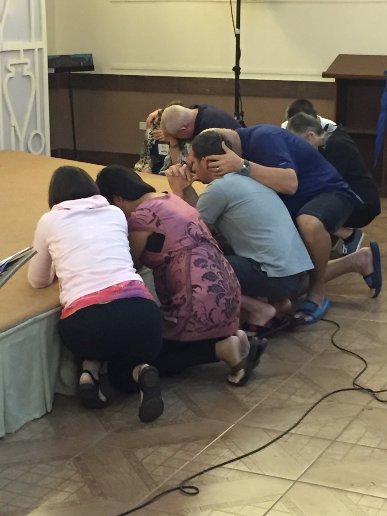 Missionaries Dar Li, Louela Page, Sam Freeman, Lisa and Fil Kakilala and Danny and Rita Ballard pray after an evening service